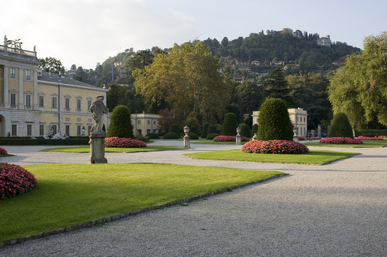 A pair of ornate pavilions framing a formal garden and lake.