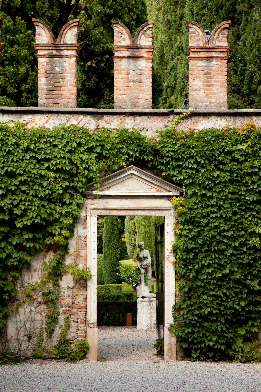 A cypress-lined allée leading to a garden pavilion.