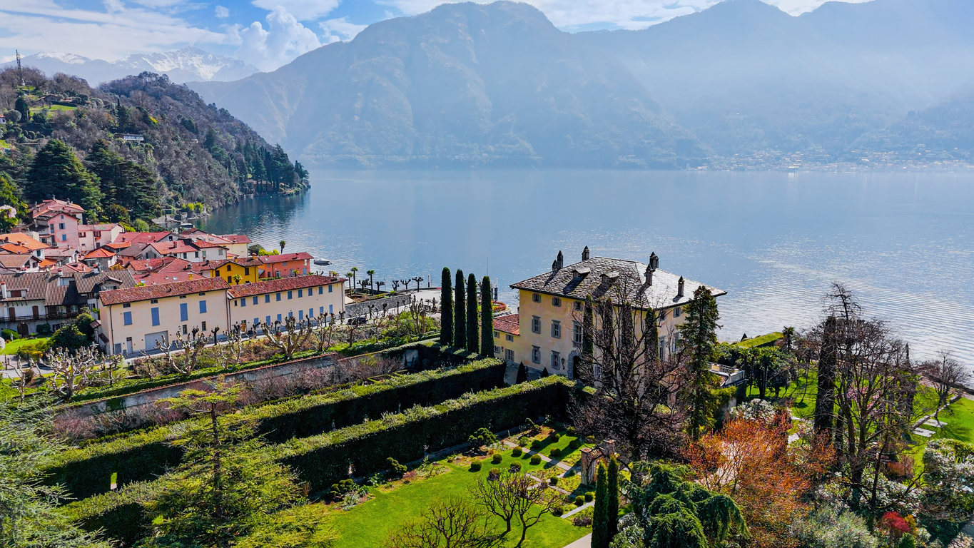 A garden terrace stepping down to an alpine lake at dawn.